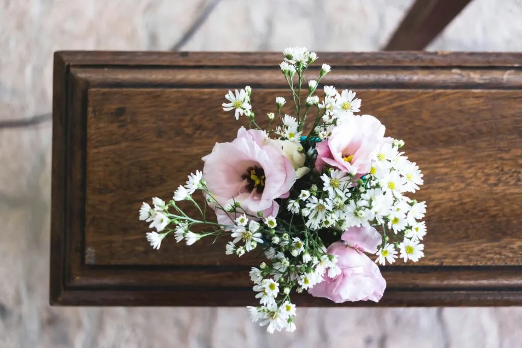 Fleurs fraîches déposées sur un cercueil en bois pour la préparation des obsèques