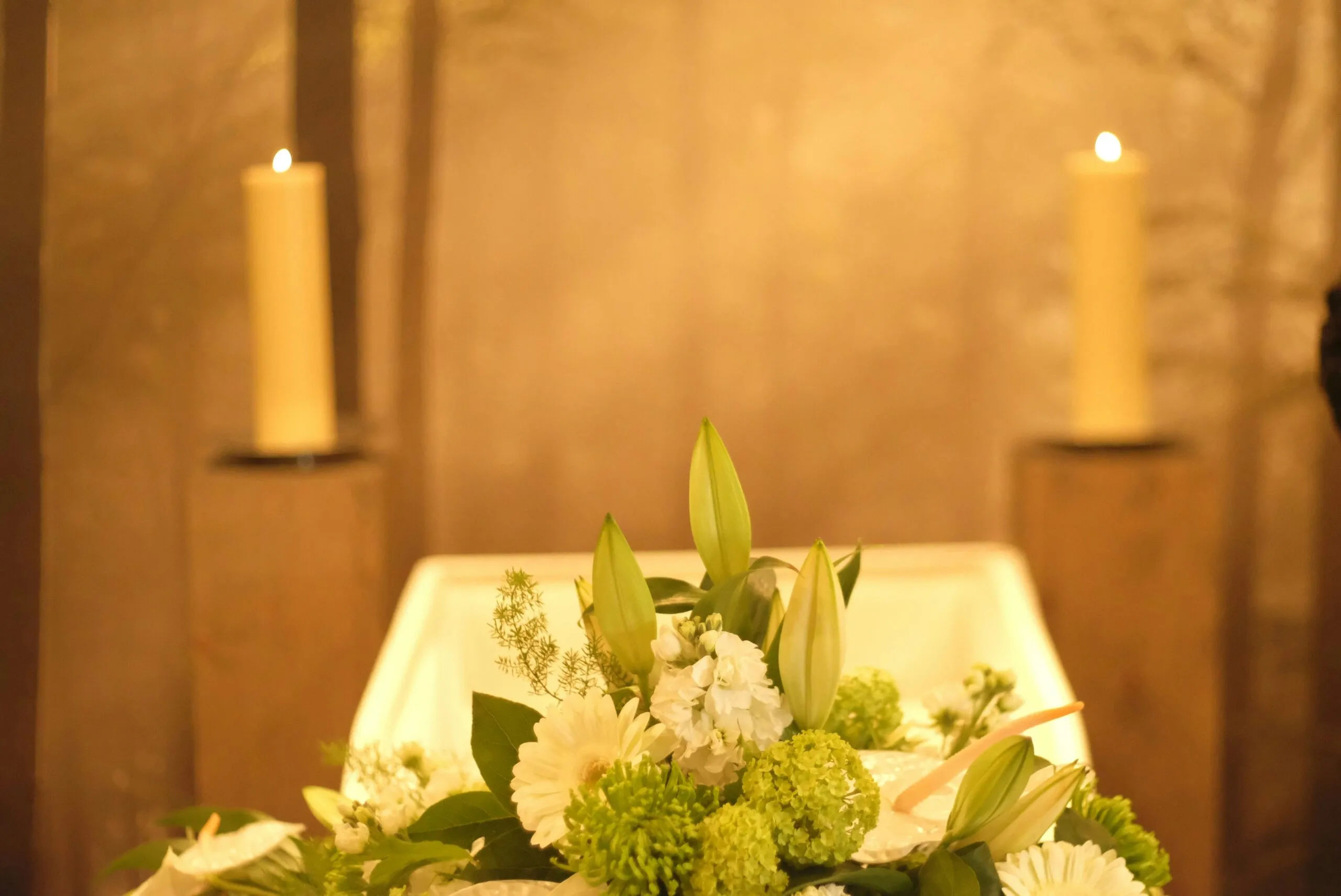 Composition florale et bougies allumées lors de la cérémonie d'hommage funéraire